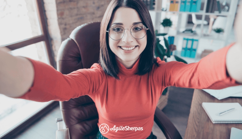 A woman holding a screen, showing her home workspace