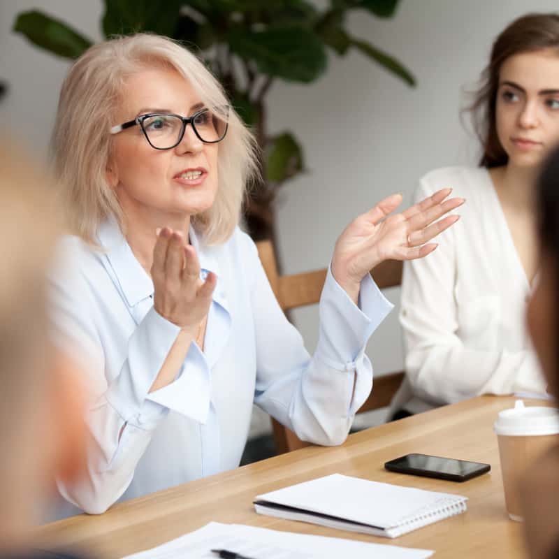 middle-aged-woman-presenting-in-meeting-400x400