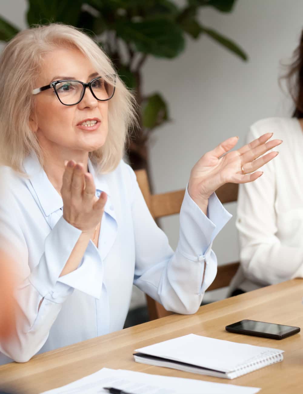middle-aged-woman-presenting-in-meeting-500x650