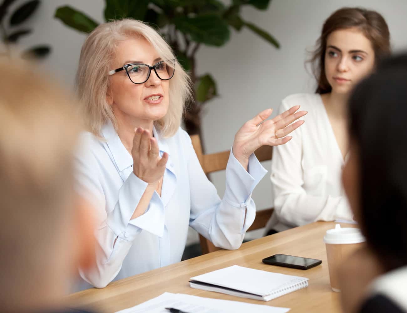 middle-aged-woman-presenting-in-meeting-650x500