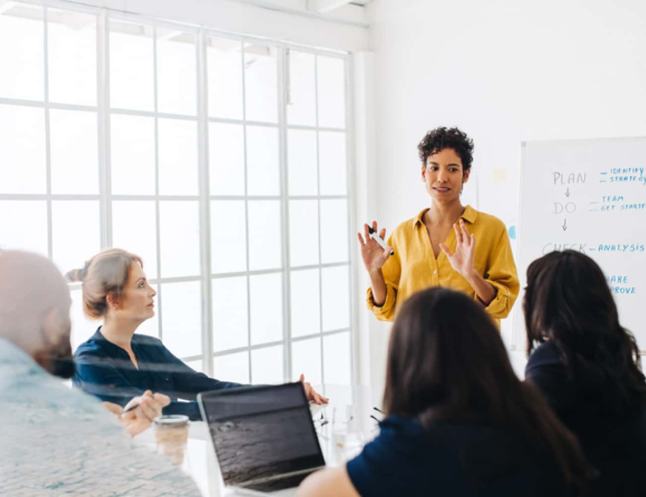 woman-standing-at-whiteboard-in-meeting-650x500